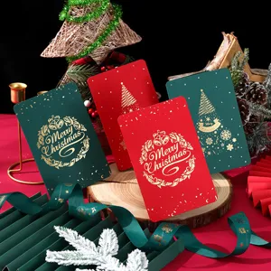 Primer plano de tarjetas de Navidad vintage rojas y verdes con elegante estampado dorado.