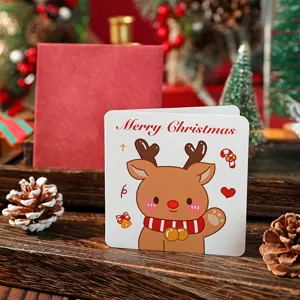 Nahaufnahme einer quadratischen Weihnachtskarte mit Rentier und rotem Umschlag