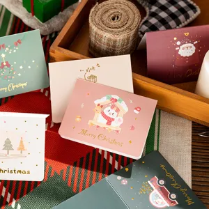 Close-up of assorted festive Christmas cards featuring gold foil lettering
