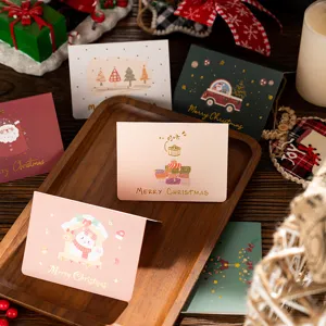 Close-up shot of assorted gold-stamped Christmas greeting cards on a rustic wooden tray