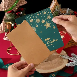 Tarjeta de felicitación navideña vintage verde oscuro con copos oro y sobre kraft