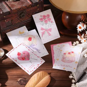 Detail of romantic floral postcards with rose illustrations on a vintage wooden desk