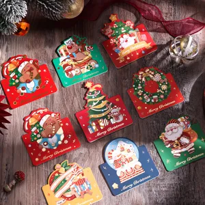 Vista dettagliata di varie cartoline di Natale vintage con lamina d'oro su tavolo in legno.