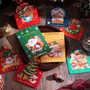 Primo piano di vari biglietti di auguri di Natale dorati su un tavolo di legno.