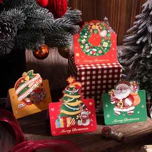 Biglietti natalizi dorati con disegni di Babbo Natale e albero di Natale in primo piano.