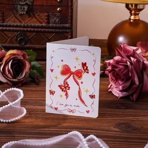 Close-up view of a vintage style greeting card featuring a red bow and love message.