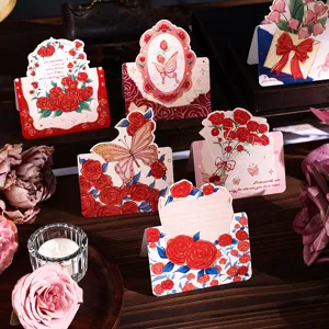 Detailansicht von vintage Klappkarten mit Rosen- und Schmetterlingsmotiven auf Holztablett