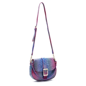 Detalle de un bolso bandolera vintage con estampado de cocodrilo y degradado azul.