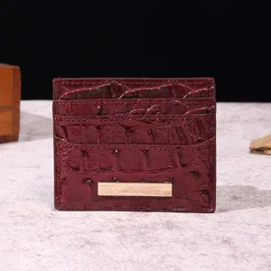 Dettaglio ravvicinato di un porta carte bordeaux vintage con elegante trama a coccodrillo