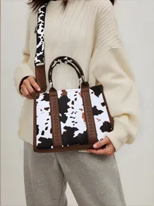 Detalle de un elegante bolso con estampado de vaca y acabados de cuero marrón