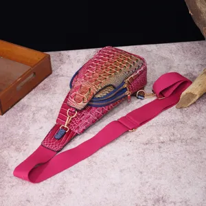 Primer plano detallado de un bolso de pecho fucsia vintage con patrón de cocodrilo