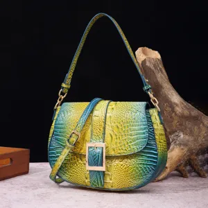 Vista detallata del bolso baguette vintage de cuero con relieve de cocodrilo verde degradado