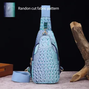 Vista detallada del bolso de pecho con relieve de cocodrilo degradado azul y correa ancha