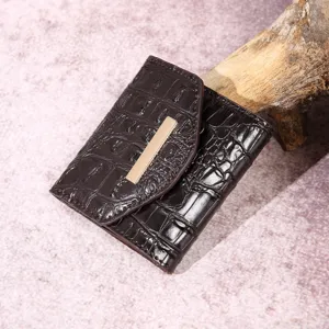 Vista detallada de una elegante cartera retro para mujer en marrón con patrón de cocodrilo