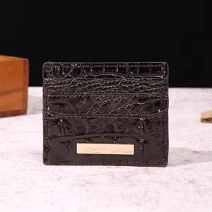 Dettaglio macro del porta carte in pelle marrone scuro con elegante trama a coccodrillo