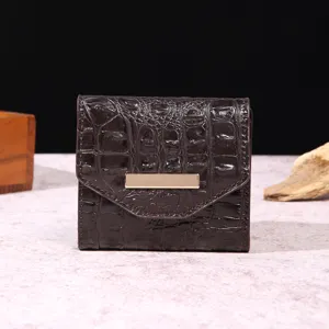 Primer plano de cartera retro para mujer en color marrón oscuro con textura de cocodrilo.