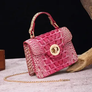 Close-up of pink crocodile embossed pattern and gold clasp on vintage handbag