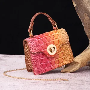 Macro detail of luxury pink gradient crocodile pattern handbag with golden metal chain strap