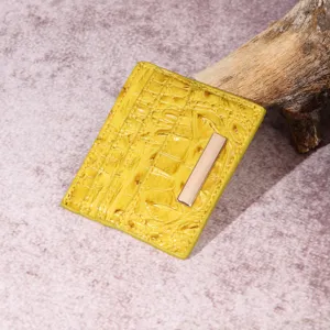 Dettaglio porta carte giallo in pelle goffrata coccodrillo con barra dorata