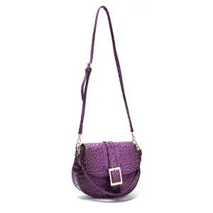Detalle del bolso de hombro morado con patrón de cocodrilo y hebilla dorada.
