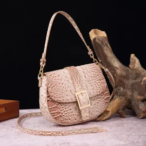 Primer plano de la textura de cocodrilo retro en un bolso baguette beige al hombro
