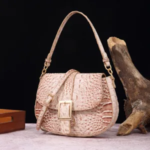 Vista detallada del cuero beige con patrón de cocodrilo y hebilla dorada