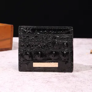 Vista dettagliata del porta carte in pelle nera con motivo coccodrillo e placca d'oro