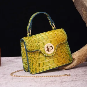 Close-up of yellow green crocodile embossed handbag featuring a gold chain strap detail