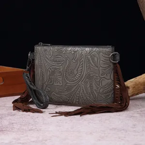 Detalle de bolso bandolera bohemio con relieve floral occidental y flecos largos