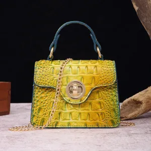 Detail view of a yellow crocodile embossed leather handbag with gold turn lock closure
