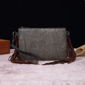 Vista detallada del bolso bohemio de cuero repujado con motivos florales vintage y borlas marrones