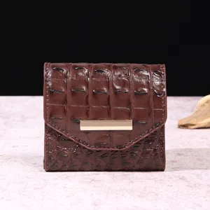 Vista detallada del patrón de cocodrilo vintage marrón en una cartera de tres pliegues para mujer