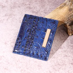 Dettaglio del porta carte in pelle blu motivo coccodrillo con accento in metallo oro