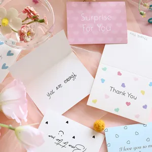 Detailed view of minimalist greeting cards with assorted English messages and heart patterns.