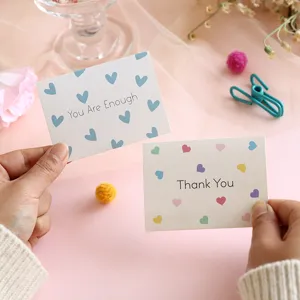 Detail view of minimalist Thank You and You Are Enough greeting cards with heart patterns.
