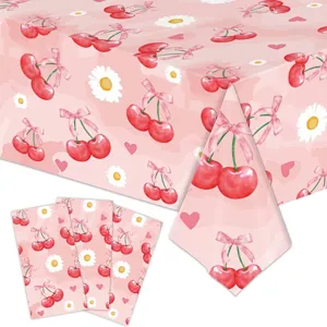 Detailed view of cherry and daisy pattern on disposable pink tablecloth and napkins.