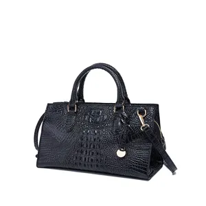 Detalle de bolso negro vintage con textura de cocodrilo y herrajes dorados