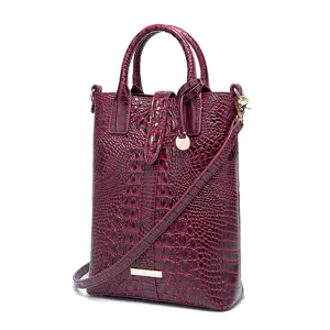 Vista detallada del bolso bordeaux con relieve de cocodrilo y detalles dorados