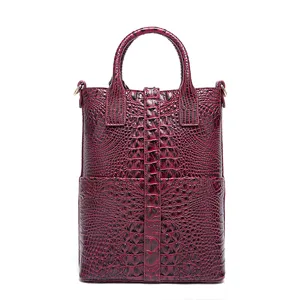 Vista detallada de un bolso burdeos de alta calidad con estampado de cocodrilo y elegantes asas