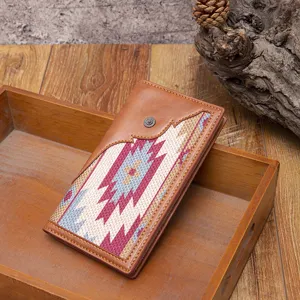 Detail of a vintage bohemian woven canvas wallet with leather trim and snap button closure.