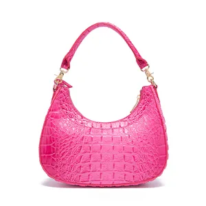 Vista dettagliata di una borsa hobo rosa acceso con stampa coccodrillo e dettagli dorati