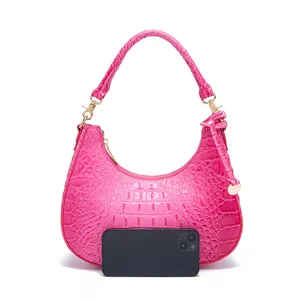 Confronto visivo delle dimensioni della borsa coccodrillo rosa con uno smartphone
