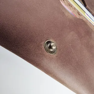 Close-up of vintage crazy horse leather card holder with metallic snap button