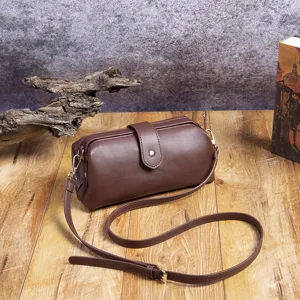 Bolso médico vintage de cuero PU marrón con cierre de metal sobre fondo de madera rústica