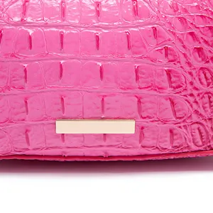 Dettaglio della pelle rosa con stampa coccodrillo e inserto in metallo dorato