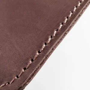 Close-up detail of hand-stitched edges on brown crazy horse leather card holder wallet