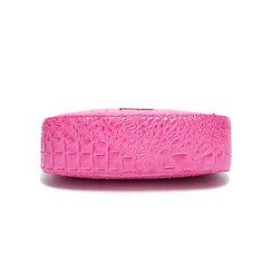 Vista dettagliata del fondo di una borsa sottobraccio rosa acceso con coccodrillo.