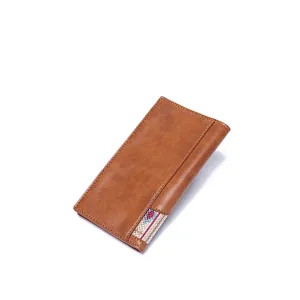 Detailed close-up view of a vintage brown leather long wallet with bohemian fabric inlay