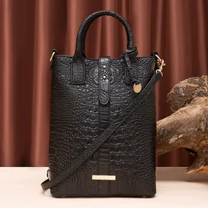 Vista detallada de un bolso negro con relieve de cocodrilo y elegantes adornos dorados