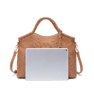 Bolso vintage marrón con relieve de cocodrilo, tamaño comparado con tableta.